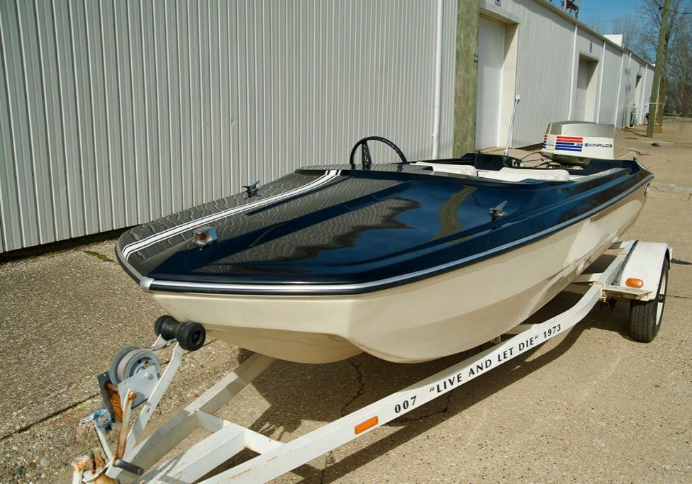 Black and white speedboat on a trailer in front of a warehouse